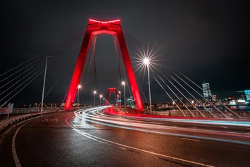 Photo sur Plexiglas Rotterdam Light trails of traffic at the Willemsbrug in Rotterdam. Beautiful red bridge. Landmark of the skyline in Rotterdam, long exposure shot. 