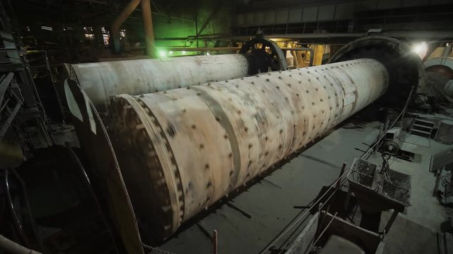 Big ball mills grinds ore on the ore-dressing factory. Rotating industrial grinders on manufacture.