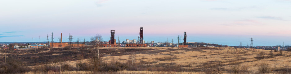 Fototapeta na wymiar Industrial concept, banner format. Industrial area of the city with mines in the foreground. An example of an industrial decline, Stebnik city, Ukraine. 