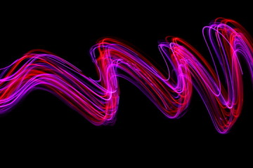 Long exposure photograph of neon red and pink colour in an abstract swirl, parallel lines pattern...