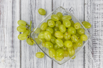 Some fresh White Grapes on wooden background (selective focus; close-up shot)