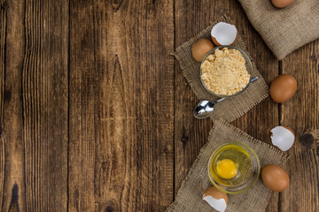 Old wooden table with fresh Powdered Eggs (close-up shot; selective focus)