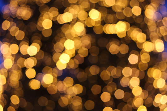 Blurred defocused picture of Christmas tree golden lights, festive background for design