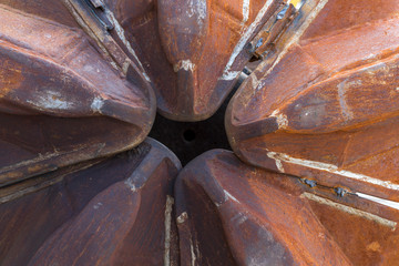 close-up of the tips of a rusty excavator shovel