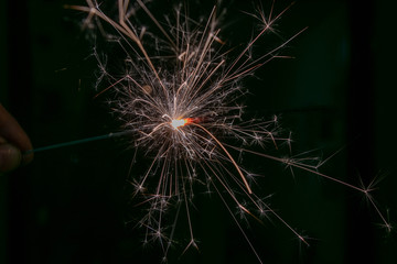 sparks from a lit sparkler on a dark background