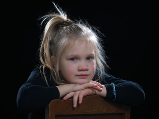 Emotional portrait of a sad girl on a black background