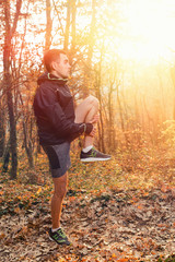 The concept of sports and cross-country running. A man in sportswear warms up during a workout. Vertical. Sunlight