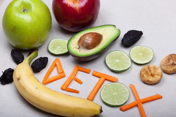 fruit and detox inscription photographed on a light stone background