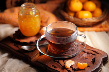 Tea with tangerine confiture on a wooden background