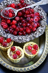 Cupcakes with cranberries and hazelnuts on a black background