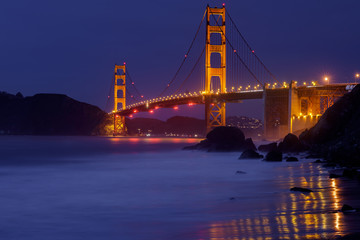 The Golden Gate Bridge glowing in the dark. Shot from Marshall Beach, San Francisco, California, USA.