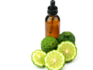 Bottles of essential oil, bergamot and sliced fruit, isolated on a white background, herbs, for health