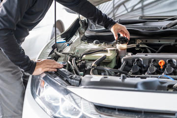 Mechanic man open cap for check brake fluid, inspection and mentenance car 