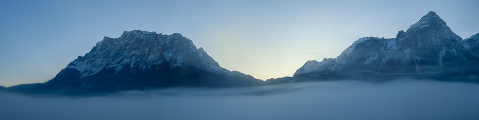 Fototapeta na wymiar The Ehrwalder Sonnenspitze and the Wetterstein Mountains, The Zugspitze on the left aerial above the clouds and fog, panorama view, Lermoos, Tyrol, Austria, Alps, Europe