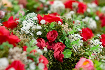 Many bouquets of red roses decorated with other white flowers and green leaves. View from above. Close up. Selective focus.