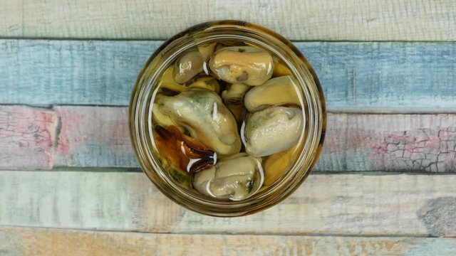 Mussels in oil. Top view of glass jar with red lid. Preserved shellfish 