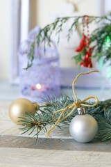 On a wooden table Christmas ball, cones, spruce branches, decorative lights, illumination, decorate the interior for seasonal winter holidays