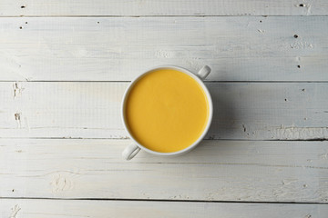 Fototapeta na wymiar Cream pumpkin soup on a wooden table