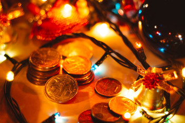 Close up shot of  Serbian money in coins surrounded with Christmas decoration. Serbian money, Christmas bell and colorful lights.