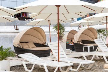 Many sun beds and umbrellas on a seashore at luxury resort, sunbathing and relaxing concept