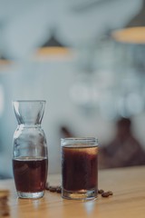 Cold brewed coffee served in a shot glass chilled on wooden table