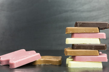 pile of bars of white, pink, milk chocolate and dark chocolate