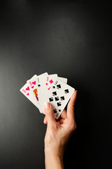 Cards in a hand on a black background. Rules and combinations of the game. Pair