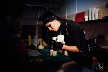 woman chef prepares fresh sushi in the kitchen of the restaurant