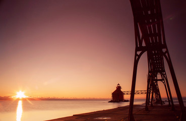 lighthouse and pier silhouette at sunrise