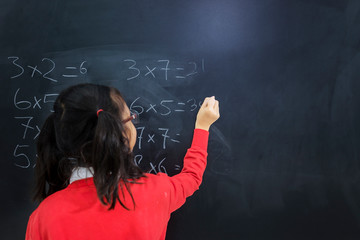 Back view of an adorable girl solving calculations