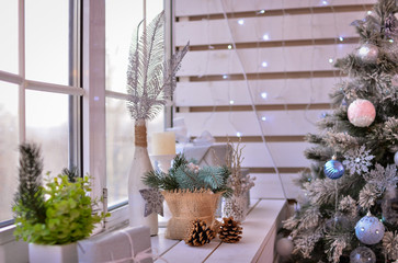 The window is decorated for the new year. Christmas tree with decorations.