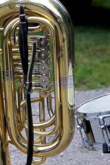 part of a tuba with leather strap and a drum