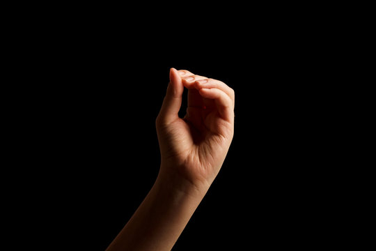 Hand Showing Sign of O Alphabet in American Sign Language (ASL), isolated on black background. Sign language