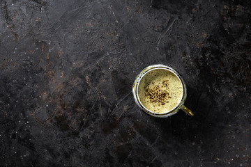 Cup of coffee on black background, top view