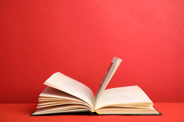 Open old hardcover book on red background. Space for text