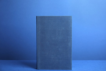 Hardcover book on blue background. Space for design
