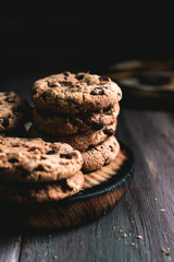 Fototapeta premium Chocolate cookies on wooden table. Chocolate chip cookies shot on black
