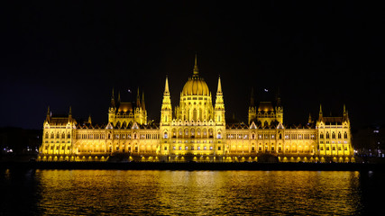 Fototapeta na wymiar Illuminated Budapest Parliament building with reflection in Danube river at night