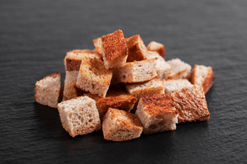 Rye crackers diced, bitter, on a dark board.