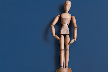 The wooden man figurine on a blue background.