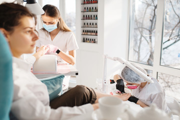 Obraz premium Two women on pedicure procedure in beauty salon