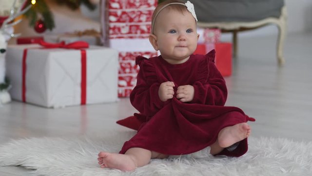 Little baby child girl fail falling during trying to sit on her but first time on parquette floor