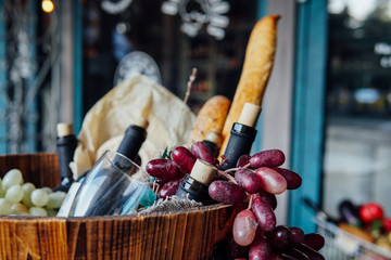 basket with bottles of wine grapes and bread