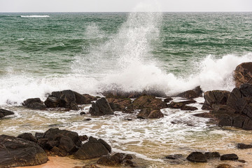 Angry waves crash over rocks on the coast during a summer storm
