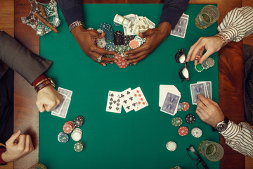 Poker players hands with cards, top view