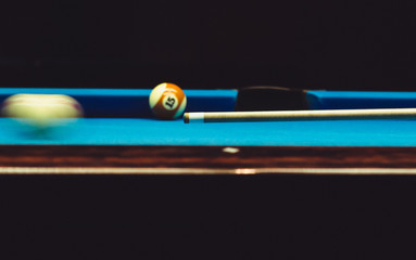 Shot of the cue starting to make the cue ball move, playing pool.