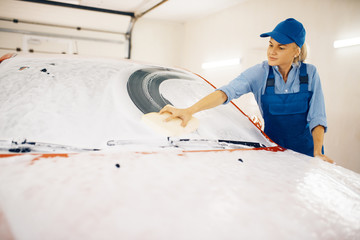 Female washer wipes the automobile windshield