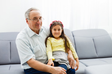 Funny lifestyle portrait of grandchild embracing grandfather