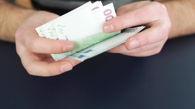 Close up of counting money. Nominal of 100 euro notes counting. Business bills money. Tax day or getting a paycheck for work. 4k slow motion footage.