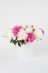 Bouquet of peonies in a white metal bucket